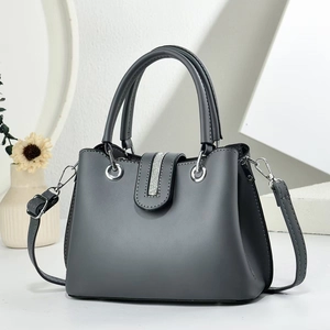 Minimalist dark grey large shoulder bag with rhinestone buckle on geometric background