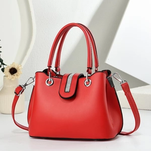 Elegant red handbag with rhinestone detail, featuring top handles and detachable strap