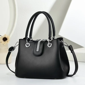 Macro shot of black PU leather bag with sparkling rhinestone strip and silver hardware