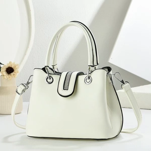 Detail of minimalist cream leather handbag with sparkling rhinestone flap and silver ring hardware