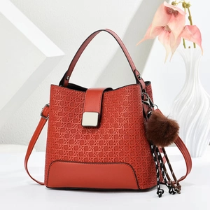 Sac seau rouge avec texture tressée géométrique et boucle argentée sur fond blanc