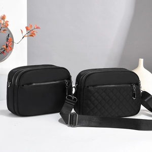 Detail of black crossbody bags featuring multi-zipper compartments and quilted patterns