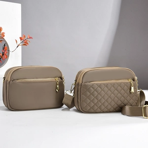 Detail of waterproof nylon crossbody bags with golden zippers and quilted texture