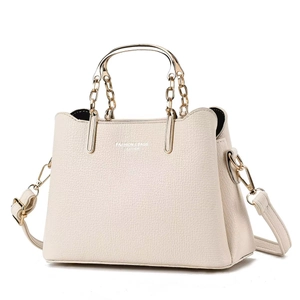 Off-white lychee leather tote bag with gold metal handles and adjustable shoulder strap