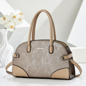 Beige textured stitching handbag with silver metallic finish and top handles on clean background