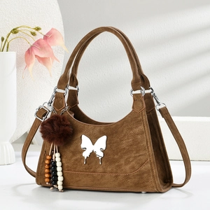Sac à main marron vintage élégant avec fermoir papillon et charme de style bohème