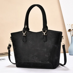 Classic black large capacity tote bag with matte finish and adjustable strap in room setting