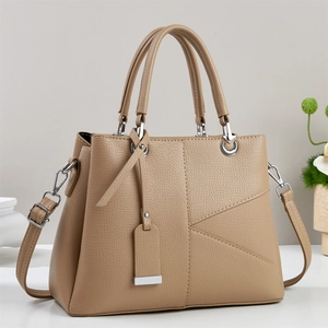 Detail of khaki pebbled leather handbag with V-shaped stitching and silver hardware