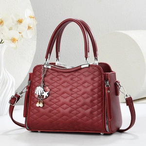 Borsa tote bordeaux trapuntata con ciondoli di perle e finiture argentate su sfondo bianco