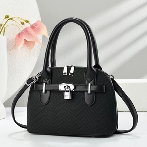 Detail of black crossbody bag with silver hardware lock and dual zipper design