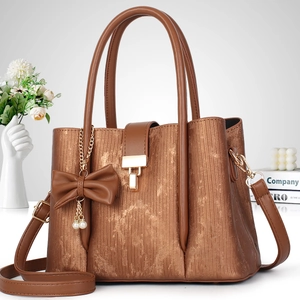 Sac à main métallique à rayures avec nœud décoratif, bandoulière et multi-couches