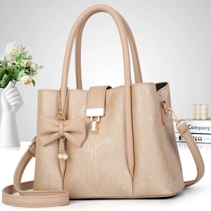 Détail du sac à main beige rayé avec nœud en perles et bandoulière amovible