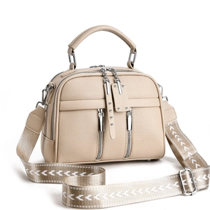 Minimalist beige crossbody bag with wide geometric strap and front zipper accents