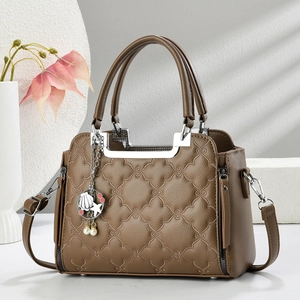 Detailed texture of brown quilted leather bag with starfish and pearl charm accessory