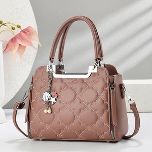 Detail of quilted mauve handbag with four-leaf clover patterns and ocean theme charms