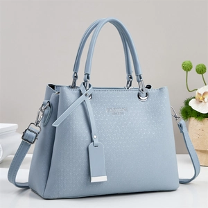 Detail of light blue crossbody bag featuring herringbone texture and silver hardware