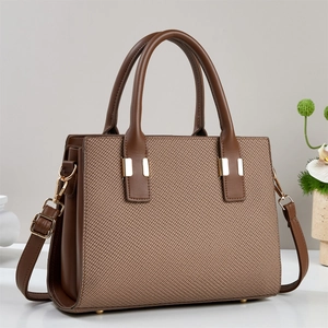 Brown woven texture handbag with golden buckle and adjustable strap in a 45-degree view