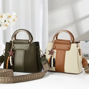 Detailed view of luxury leather handbags with gold ring handles and ethnic woven straps