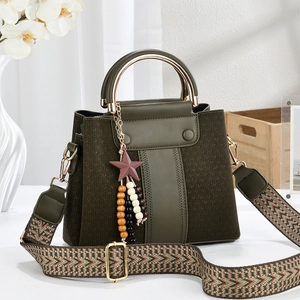 Detail of dark green leather handbag with woven fabric and circular metal handle