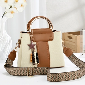 Detail of color-block tote with gold ring handle and bohemian patterned strap