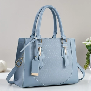 Detail of light blue faux leather handbag with woven texture and gold-tone hardware