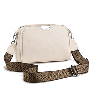 Close-up of beige lychee leather crossbody bag with bohemian woven shoulder strap