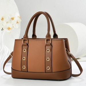 Classic dark brown pebble leather tote bag with gold eyelet accents and shoulder strap