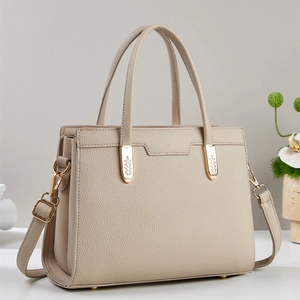 Beige pebble leather tote bag with gold hardware and adjustable crossbody strap