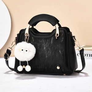Sac à main noir classique avec détails dorés et décoration de charme en peluche blanche