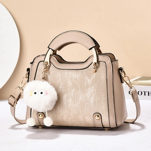 Sac à main beige élégant avec rayures scintillantes et charmant pendentif en peluche