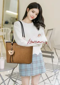 Brown faux suede tote bag with plush bear charm and brand logo detail on front
