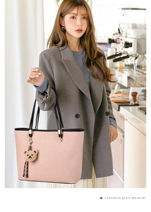 Detail of pink crocodile leather tote bag with gold logo and cute bear charm pendant
