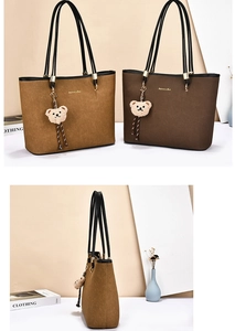 Detail of two matte suede tote bags in camel and brown with golden logo and bear charms