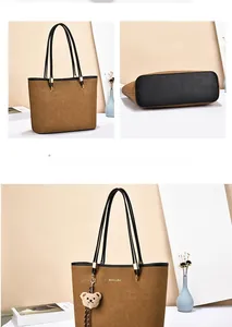 Detail of brown suede tote bag with black base, golden logo and cute bear charm