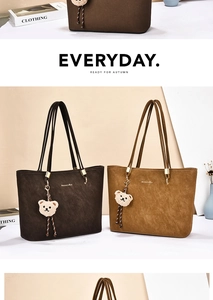 Detail of vintage suede tote bags in brown shades featuring plush bear charms and gold rings