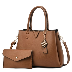 Détail du sac à main en cuir marron grainé avec boucle dorée et petite pochette