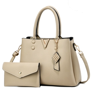 Ensemble sac cabas en cuir grainé beige avec garnitures dorées sur un fond blanc neutre