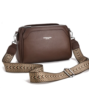 Brown lychee leather crossbody bag with a colorful geometric patterned wide shoulder strap