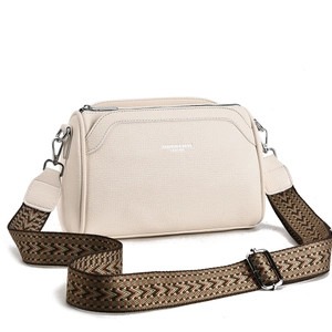 Detail of cream lychee leather handbag with wide geometric woven shoulder strap
