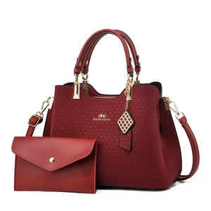 Red textured tote bag with matching envelope wallet and gold pendant accessories