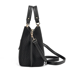 Detail view of black woven texture shoulder bag with premium golden hardware accents