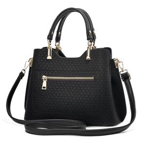 Detail of black woven texture leather handbag with gold zippers and detachable strap