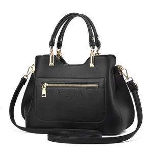 Detail of elegant black lychee pattern leather handbag with premium gold hardware accents