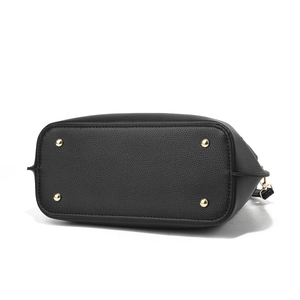 Detail of black pebbled leather handbag bottom with four protective gold metal studs