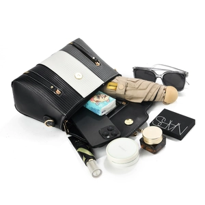 Detail view of the interior capacity showing a crossbody bag holding cosmetics and an umbrella