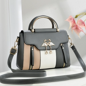 Detail of the golden swan-shaped lock and premium color-block faux leather of the handbag