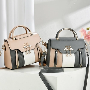 Detail of vintage crossbody bags with swan buckles, pearl charms and striped panels