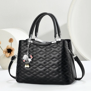 Elegant black quilted leather handbag with shell pendant and geometric props display