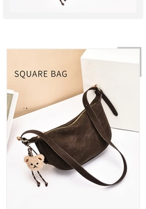 Detail of dark brown suede half-moon shoulder bag with cute plush bear charm accessory