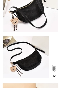 Detail of black suede hobo bag with slim leather strap and cute plush bear charm detail